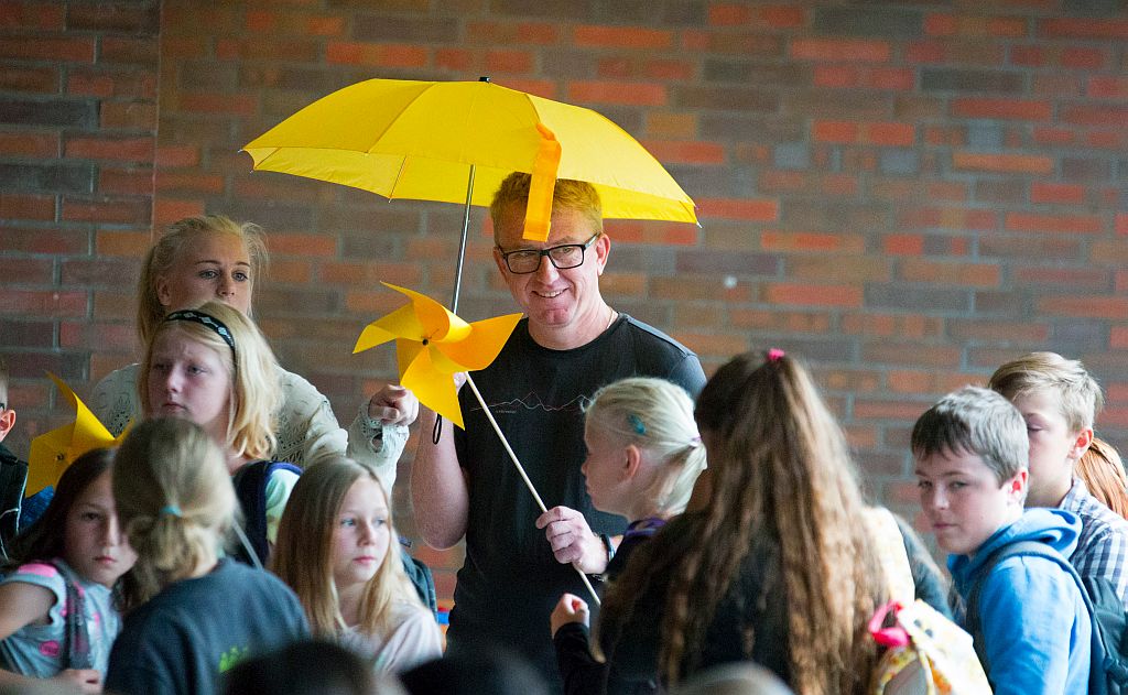 Lehrer mit gelben Regenschirm