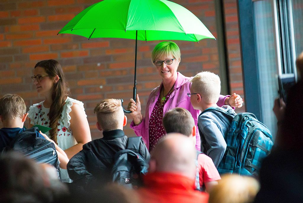 Lehrerin mit grünen Regenschirm