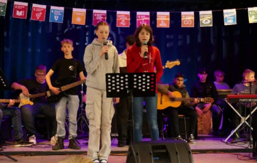 Sommerfest 2024 IGS Friesland-Süd, singende Schulkinder auf der Bühne.